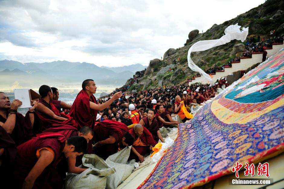 ལྷ་སའི་ཞོ་སྟོན་དུས་ཆེན་འགོ་བརྩམས་པས་དད་ལྡན་མང་ཚོགས་དང་ཡུལ་སྐོར་བས་འབྲས་སྤུངས་དགོན་གྱི་གོས་སྐུར་མཇལ་བཞིན་པ།