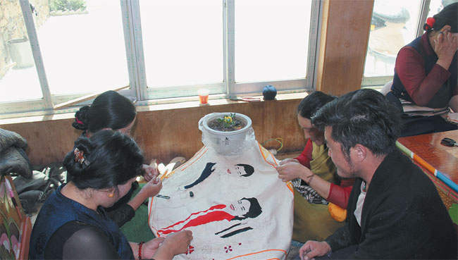 ལི་ཐང་གི་བོད་རིགས་བུད་མེད་ཀྱིས་རང་ཉིད་ཀྱི་ལག་གཉིས་ལ་བརྟེན་ནས་དབུལ་སྒྲོལ་ལམ་བུ་བཏོད་པ།